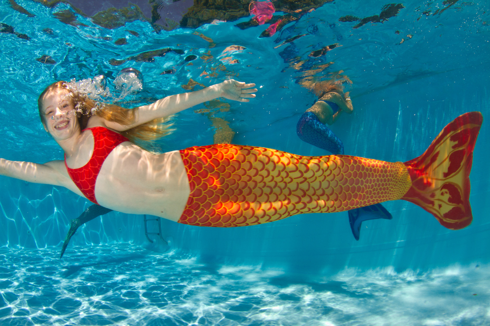 sereia da calda laranja nadando na piscina