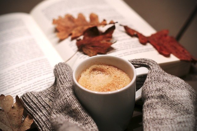 pessoa com frio segurando uma xícara de chocolate quente