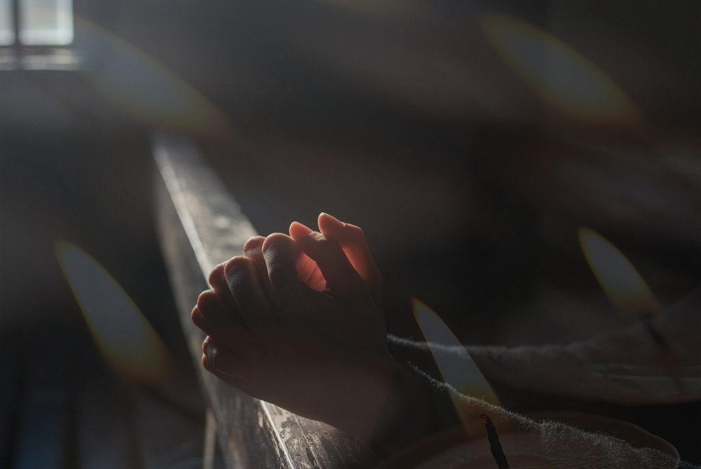 mãos juntas orando na igreja